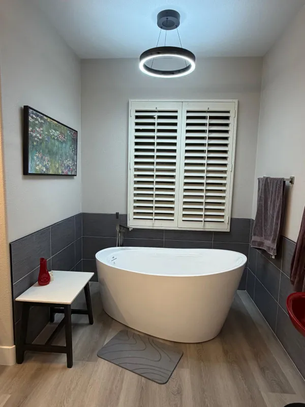 Luxury white freestanding bathtub with modern gray wall tiles in a remodeled Temecula master bathroom